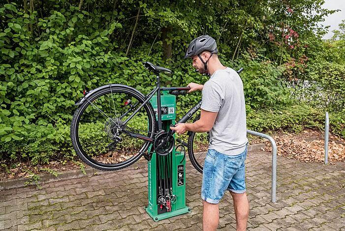 Mand fikser sin cykel ved cykelservicestation